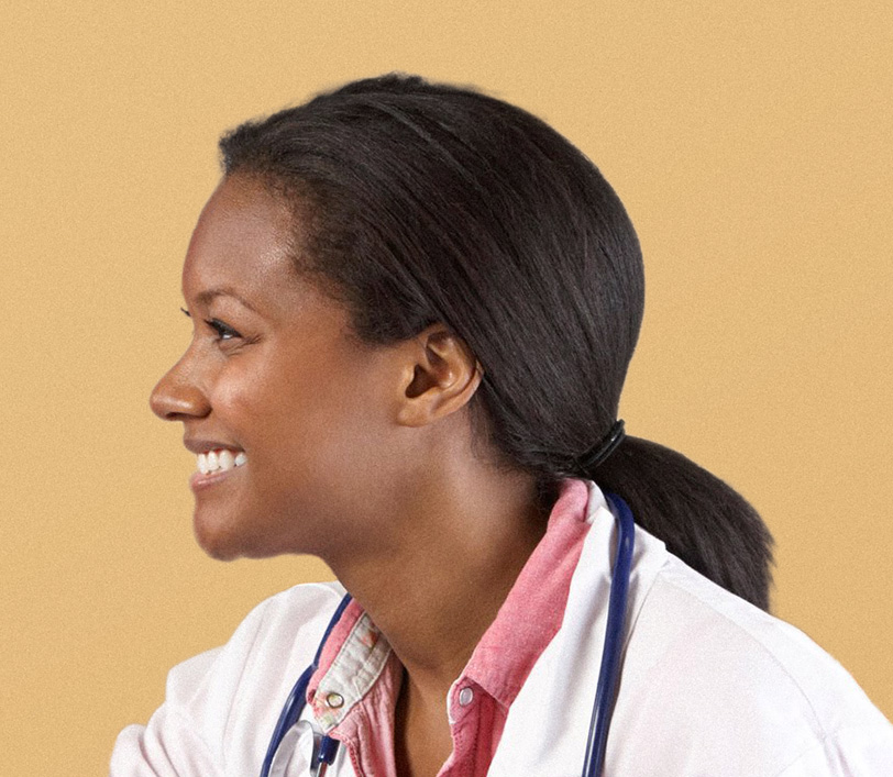 A smiling young Black woman, looking to the left toward a Black male patient